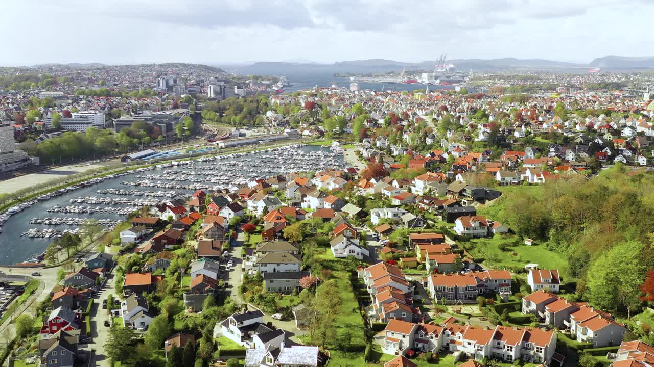 Stavanger, Norja. Drone-ilmakuva Vardenin kaupunginosasta ja veneistä venesatamassa kevätauringossa.