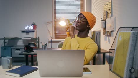 young man working in home office, throwing baseball