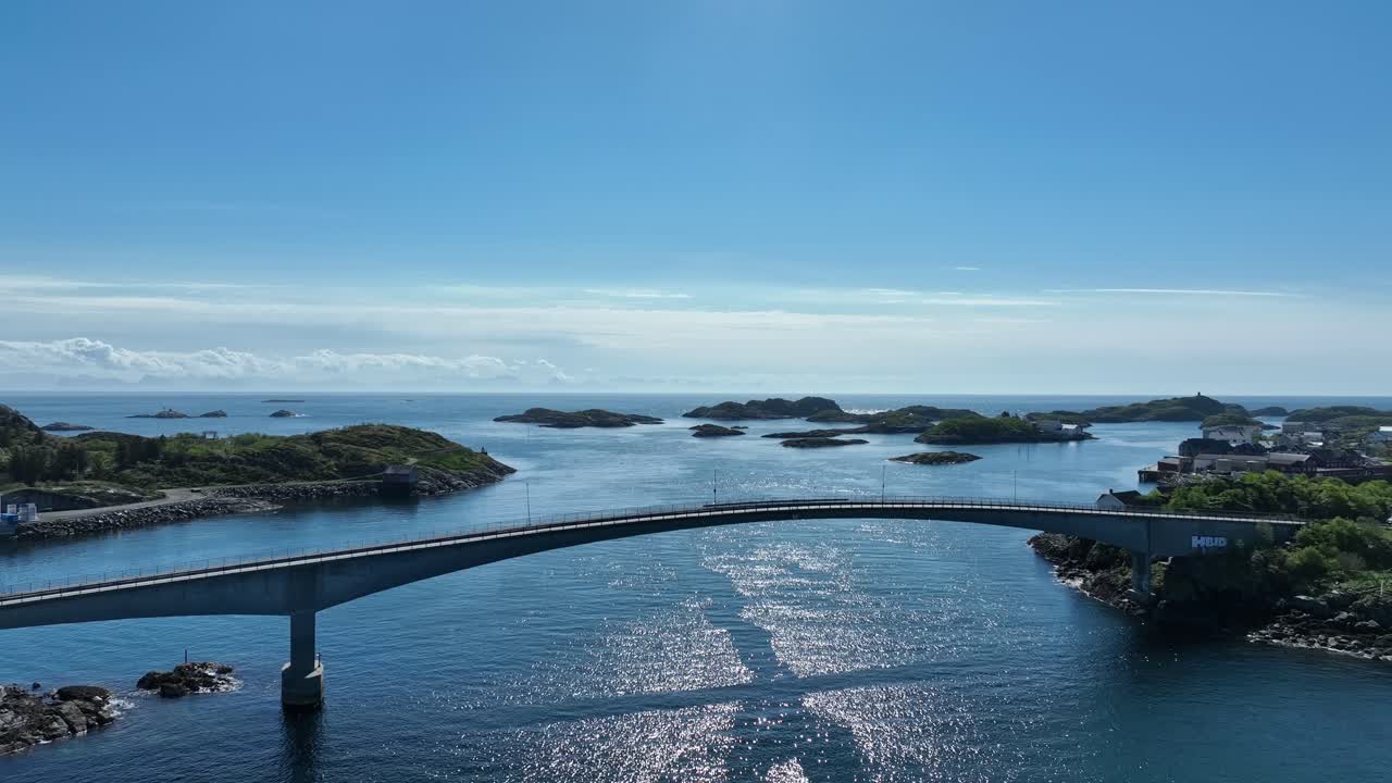 Henningsvaer bridge in Lofoten linking road and islands over sea under clear summer sky and horizon