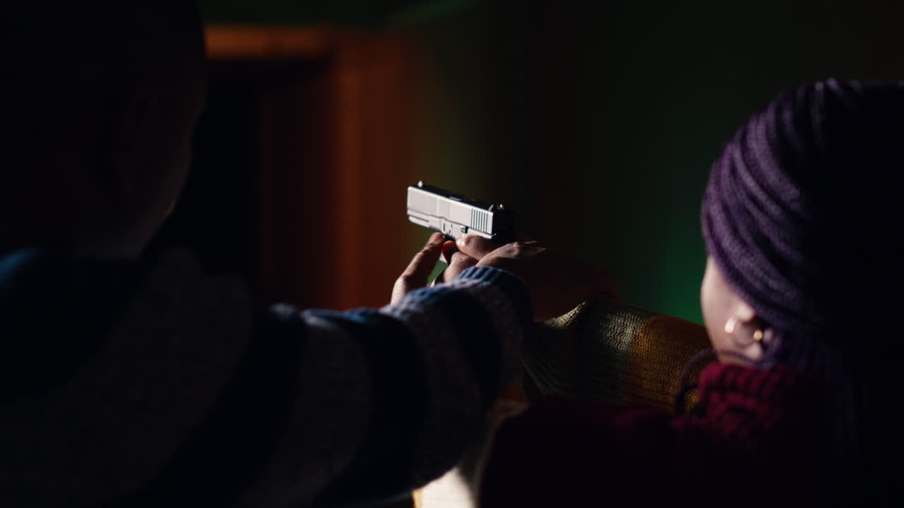 Shooting gallery worker teaching student how to hold pistol, close up