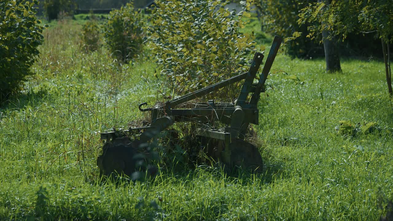 Rusty abandoned plow overgrown with grass and bushes in Lonjsko Polje Krapje