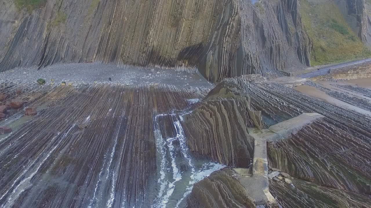 toma aérea estática del flysch de zumaia con las olas entrando en las rocas