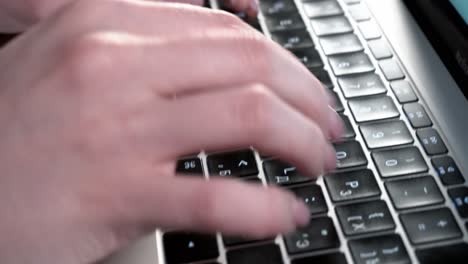 manos femeninas presionan teclas en el teclado de un macbook con un diseño ruso
