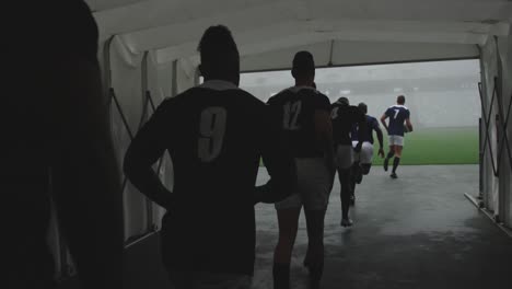 male rugby players running together in a row at the entrance of stadium 4k