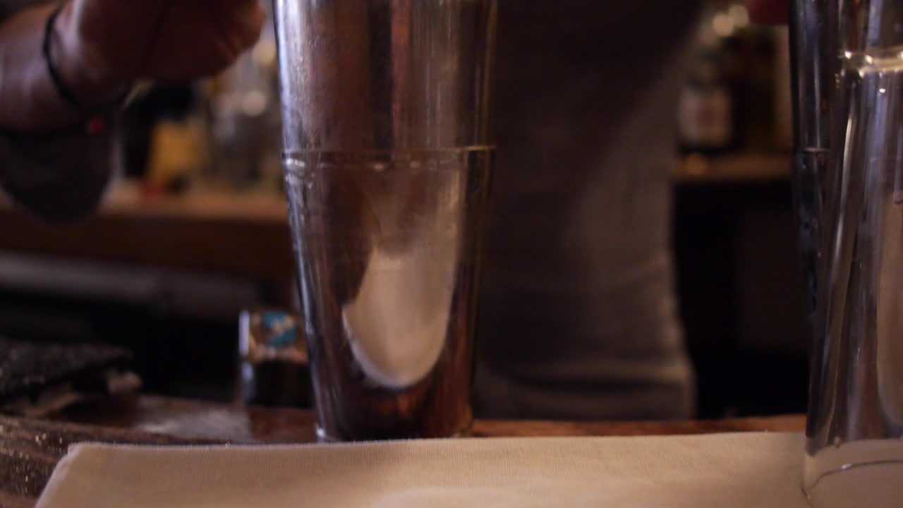 Bartender Using Shakers for Whiskey Cocktail at Bar
