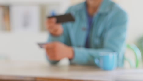 man at home using banking app taking picture of credit card with mobile phone