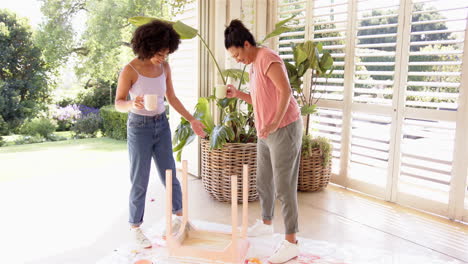 assembling furniture, mother and adult daughter working together in bright living room
