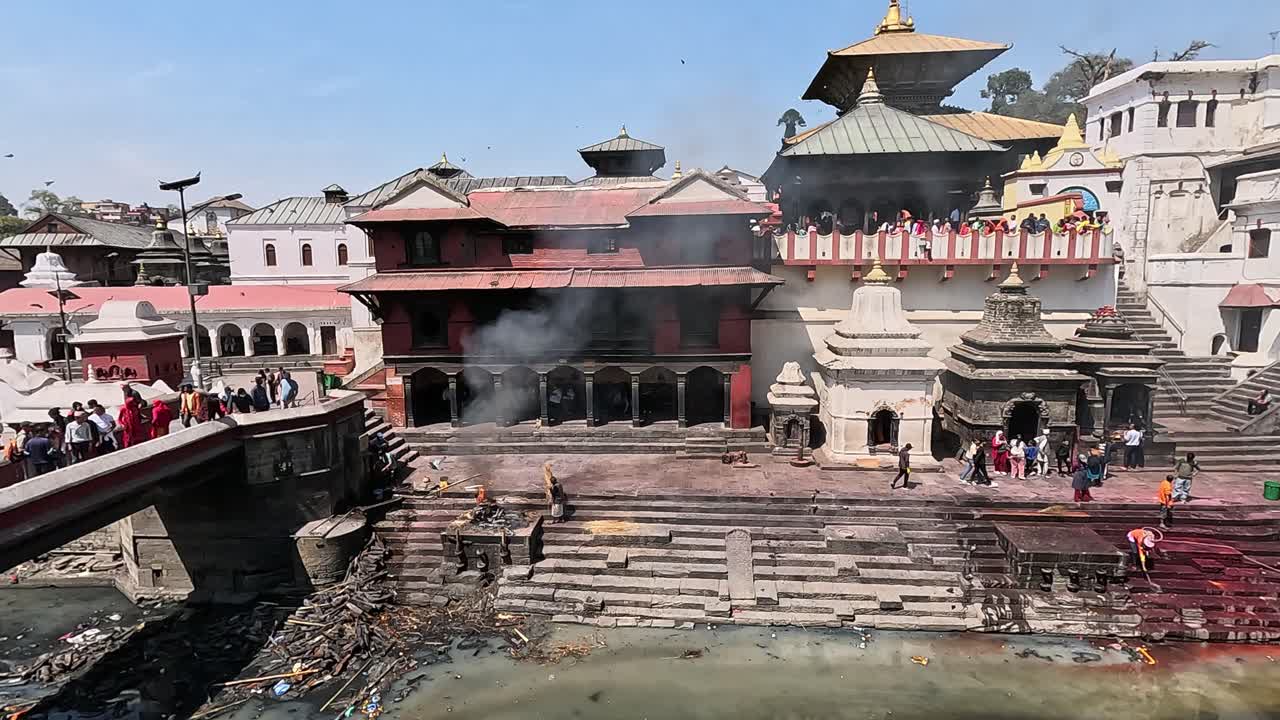 Pashupatinath Temple Cremation Complex on the banks of sacred Bagmati River in Kathmandu, Nepal. Overlooking white mausoleums, roofs of Pandra Shivalaya