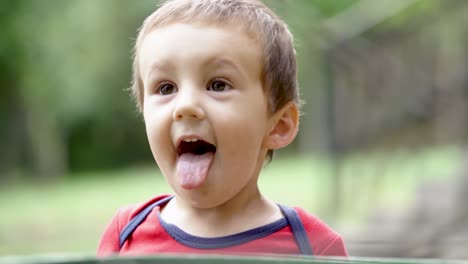 young caucasian boy making funny faces and sticking his tongue out, slow motion