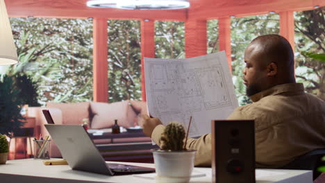 entrepreneur analyzing architectural sketches and blueprints at his home