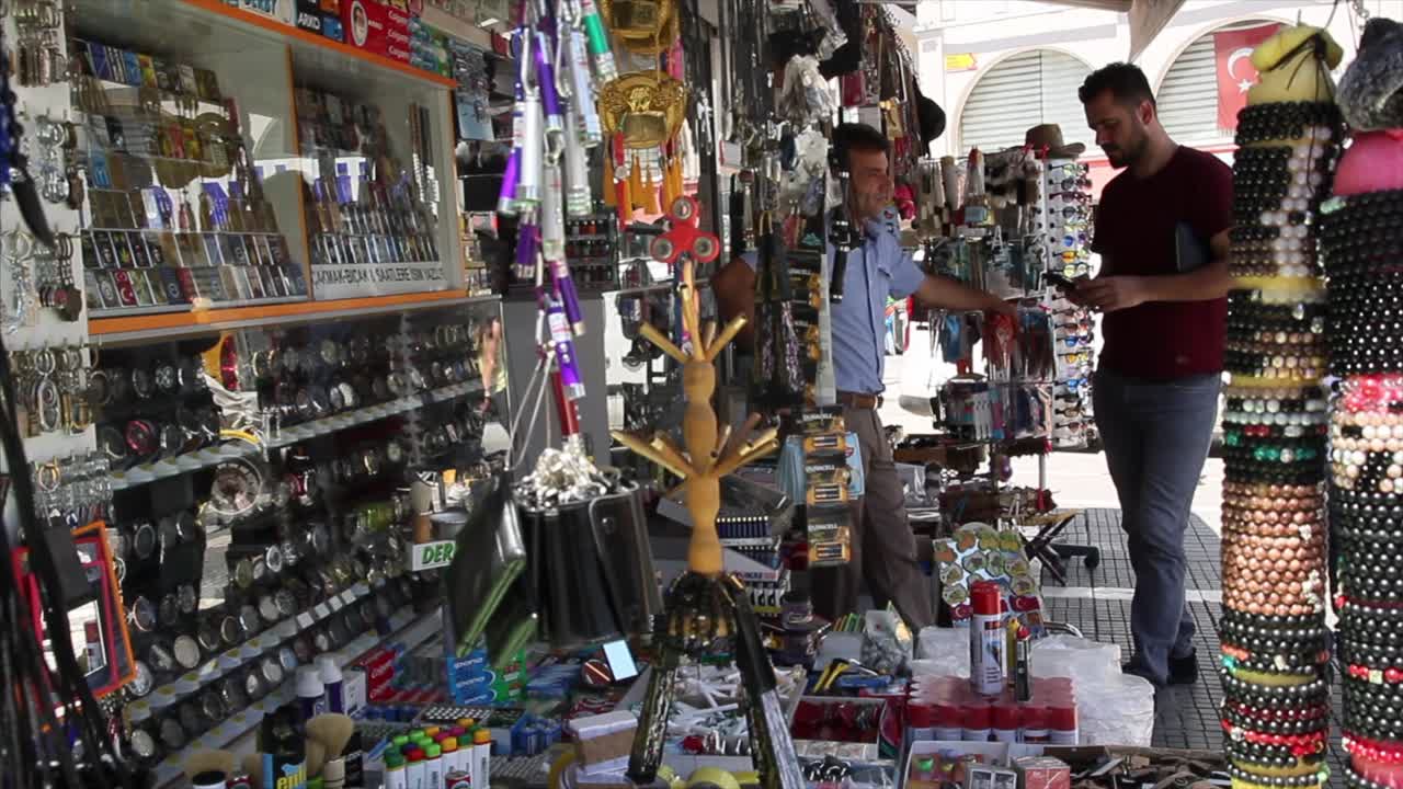 Men browsing various goods at an outdoor market stall