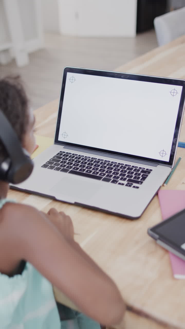 Vertical video of biracial girl using laptop with copy space, slow motion