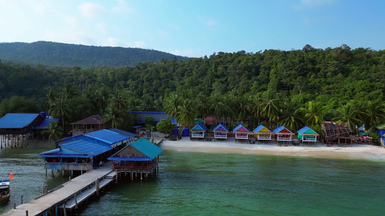 colorful bungalows rising on a tropical beach in Koh Rong island, Cambodia. Fantastic aerial view flight dolly right drone