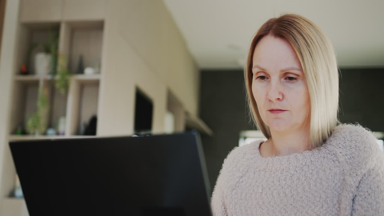 mujer de mediana edad trabaja en casa, usa una computadora portátil. trabajo remoto desde casa