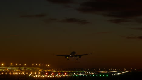 Start--Und-Landebahn-Des-Flughafens-Barcelona-Beleuchtet,-Flugzeuglandung-Am-Frühen-Abend