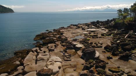 Drone-shot-of-Tribune-bay-park-rock-formations-with-reveal-of-two-people