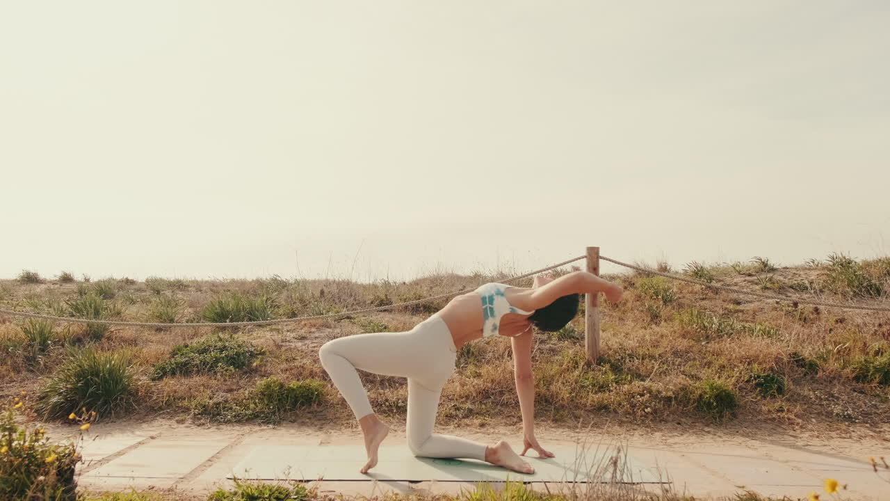 Young Woman Practicing Yoga and Stretching Outdoors on a Sunny Day