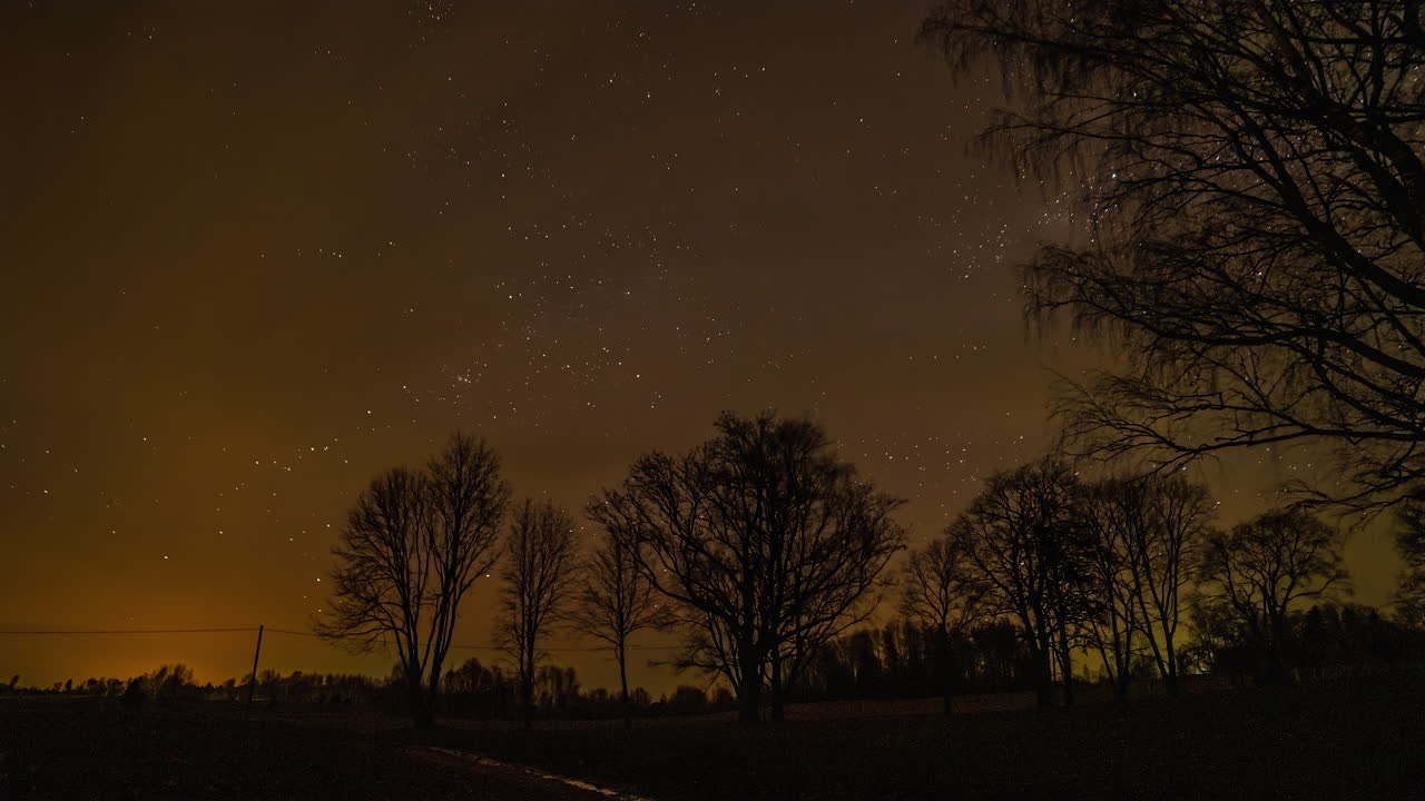 Timelapse of an evening sky as stars are moving throughout the night sky as few clouds pass through the sky