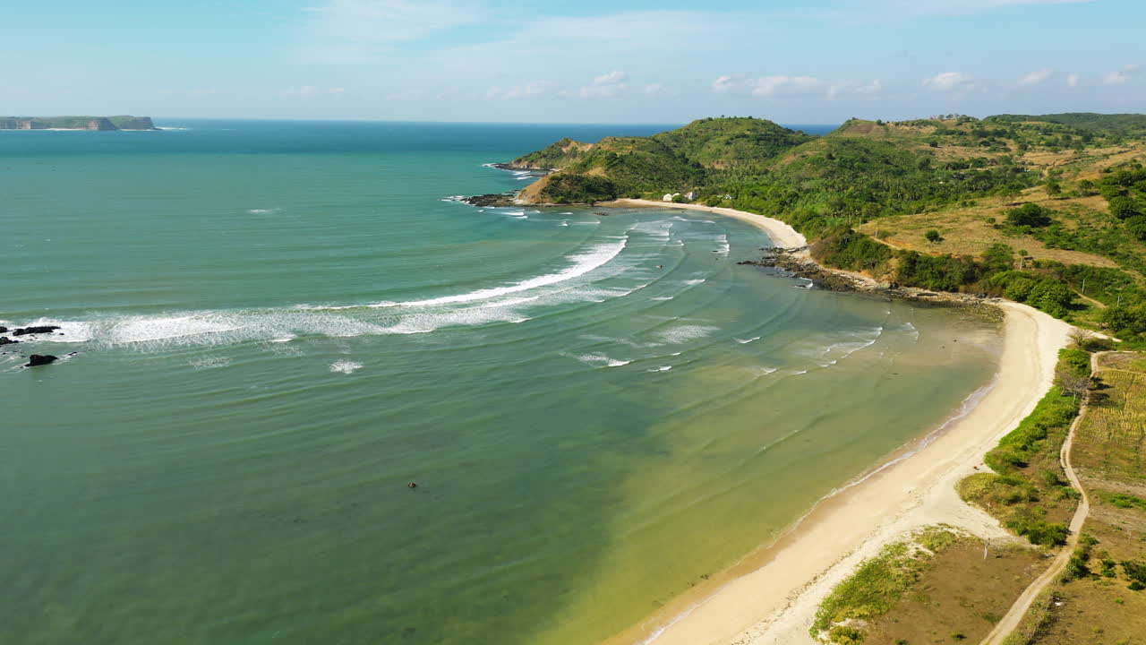 Volo aereo sopra la costa con spiaggia sabbiosa e oceano a Teluk Awang, Lombok.