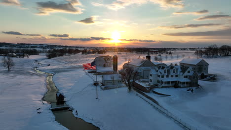 family farm in winter snow at sunrise