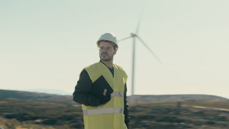 a renewable energy engineer in reflective gear checks wind turbines while walking in a field of renewable energy generators, emphasizing the importance of maintenance for a sustainable energy future