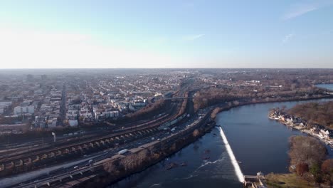 an aerial shot of the suburbs of philadelphia flying along the river and highway, pennsylvania