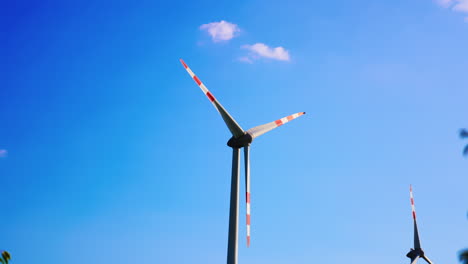 windmill blades rotating slowly. low angle view at the wind turbine at the backdrop of blue sky.