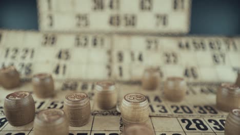 video macro de un tablero de bingo, luces de estudio, 120 fps, cámara lenta, dígitos de chips de madera, imágenes en bruto, juego de mesa de lotería, números de cartas, movimiento de retroceso de la grúa