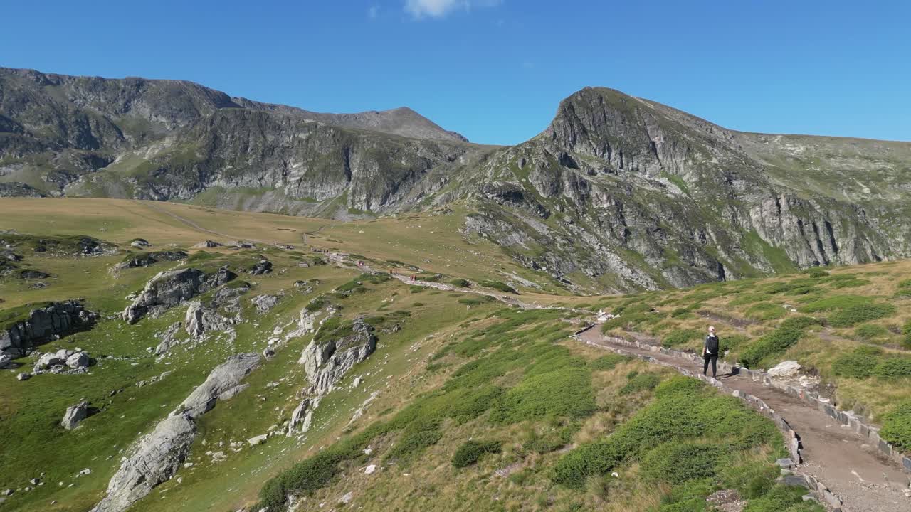 mujer camina por el sendero de montaña a los siete lagos de rila en bulgaria, balcanes