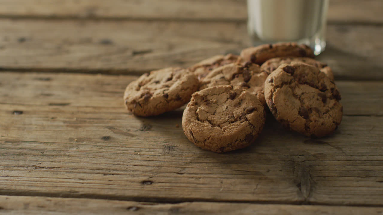 Video of biscuits with chocolate and milk on wooden background