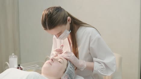 cosmetologist performing facial injection procedure