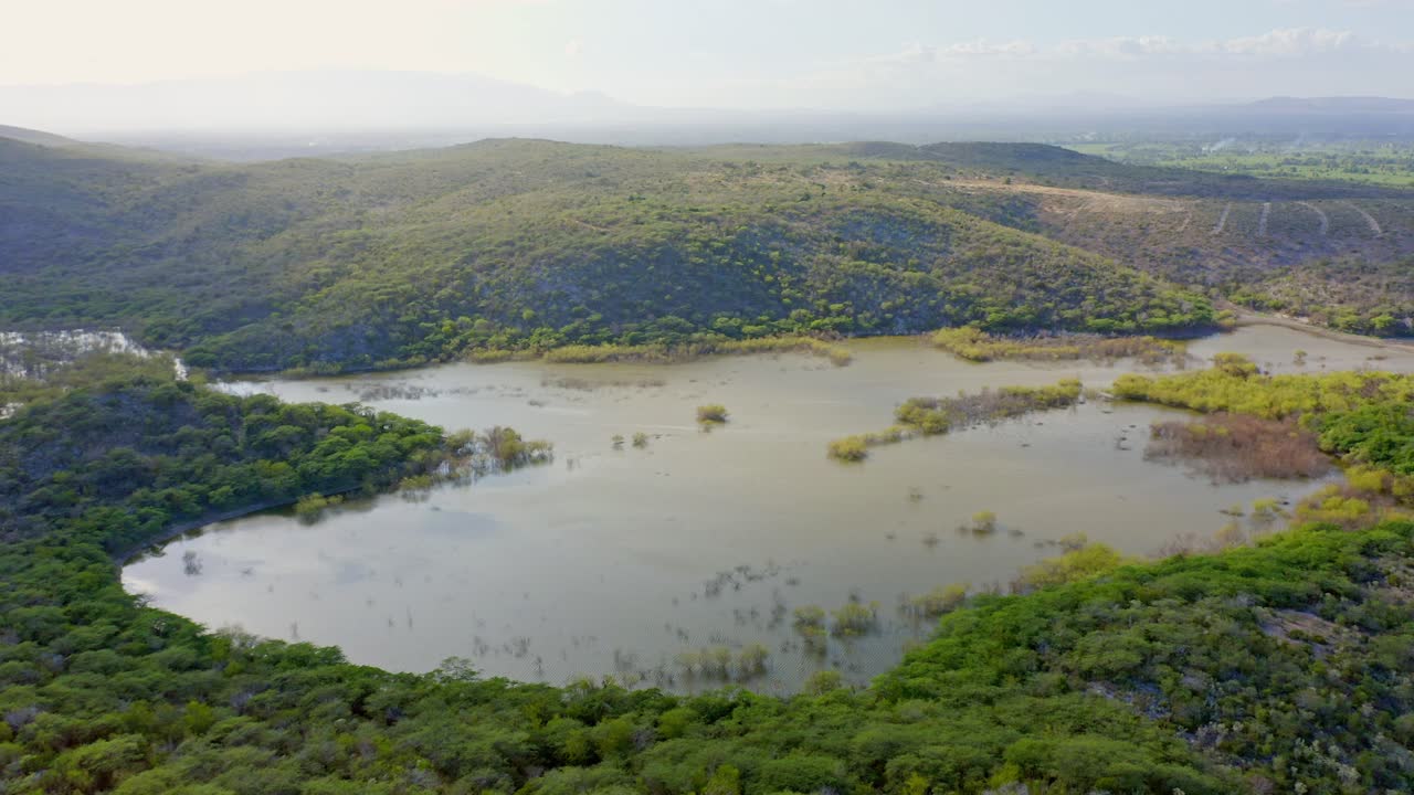 vista aérea montañosa panorámica mientras la luz del sol se refleja en las aguas del bosque de manglares, provincia de azua, república dominicana