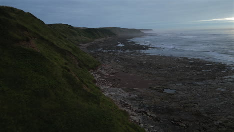 establishing aerial drone shot close to cleveland way cliffs on misty morning in scarborough