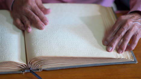 lectura de un libro en braille por un anciano