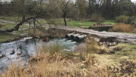 streams of water flow through concrete sewers. polluted body of water in the park. drone shooting.