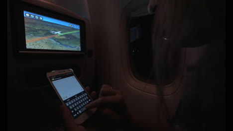 Mujer-Escribiendo-SMS-Durante-El-Vuelo-Nocturno