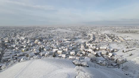 Casas-De-Pueblo-Nevado-Vista-En-La-Azotea-Desde-La-Cima-De-La-Colina-Nevada-Con-Viñedo-En-Zell-weierbach,-Offenburg,-Alemania---Toma-Aérea-De-Drones,-Adelante