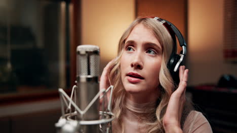 woman singing into a microphone in a recording studio