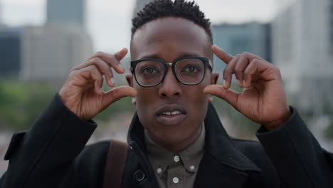 portrait successful african american man student preparing for job interview checking glasses in urban city slow motion