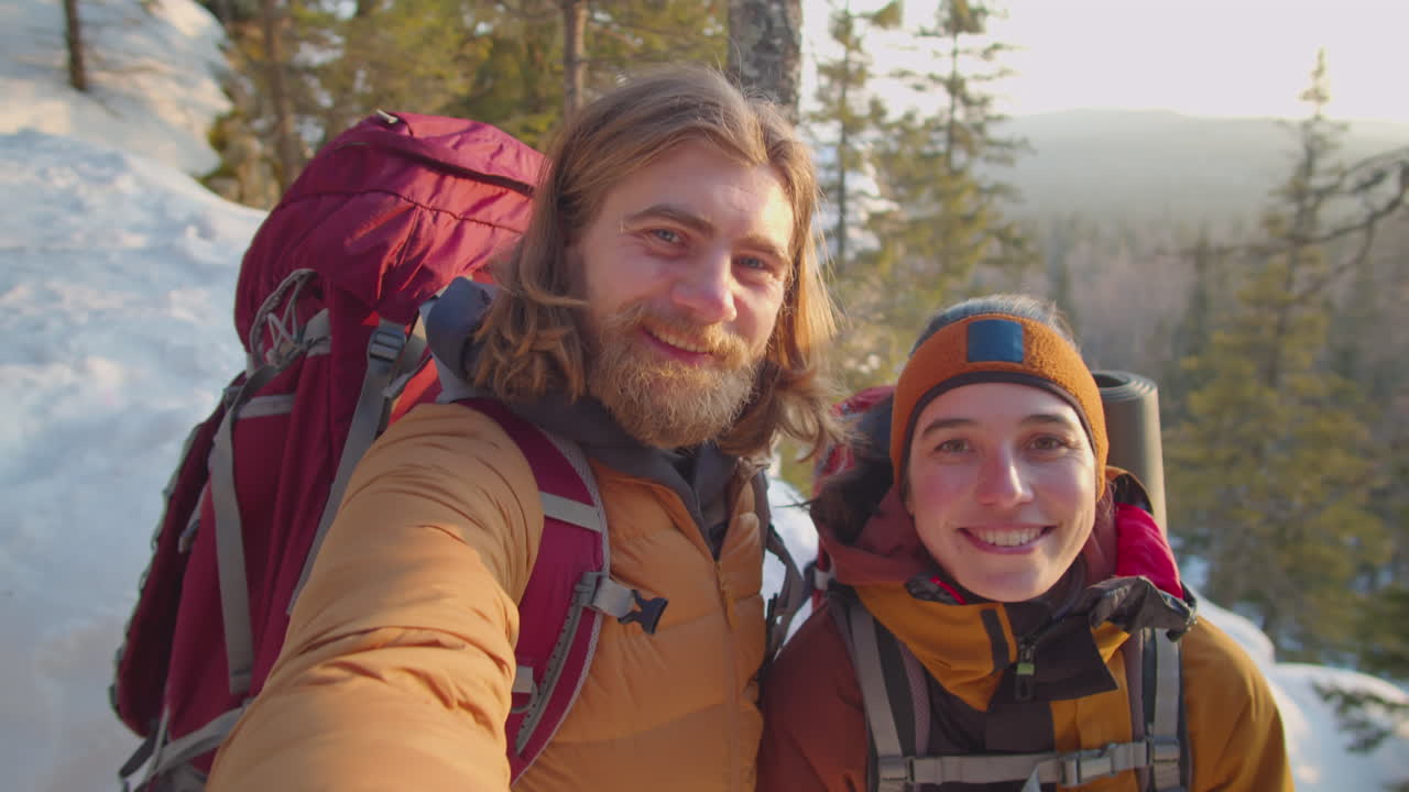 Onnelliset turistit ottavat selfien lumisella vuorella