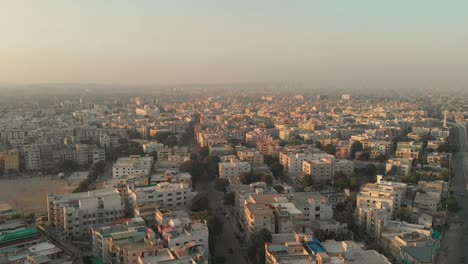 Aerial-View-Over-Apartment-Buildings-In-Karachi-During-Sunset-With-Birds-Flying-Past