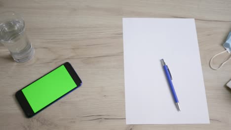 top view from above a table with papers and coffee ready to work, office before working hours. phone on the table, green screen.