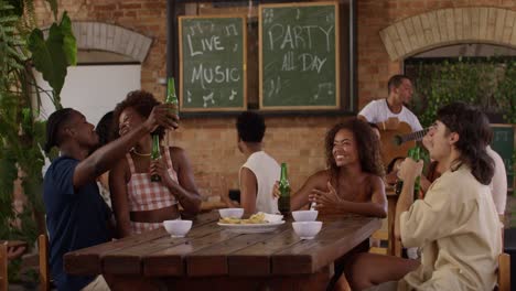 Friends enjoy a lively party with live music and drinks at a bar