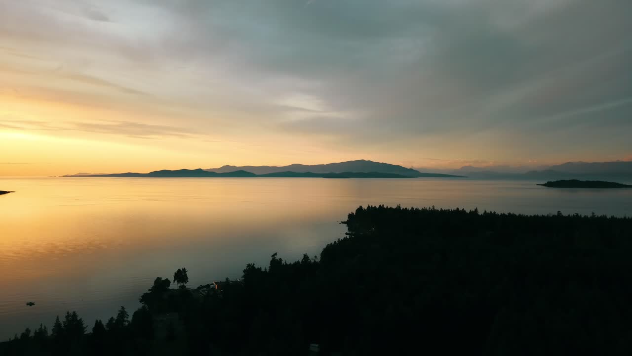 Droneudsigt der panorerer opad til venstre vest for en spektakulær solnedgang over Vancouver Island