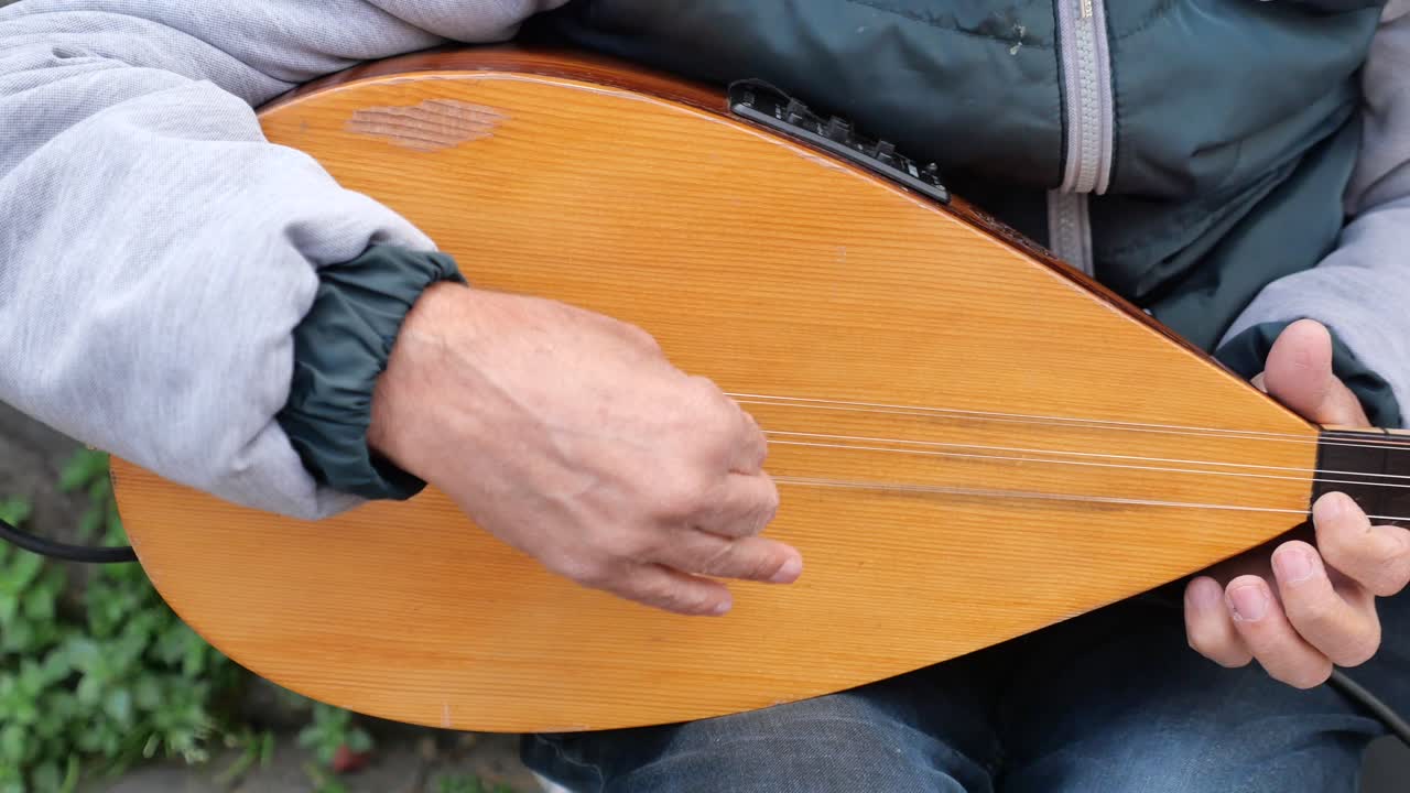 un hombre tocando un saz turco