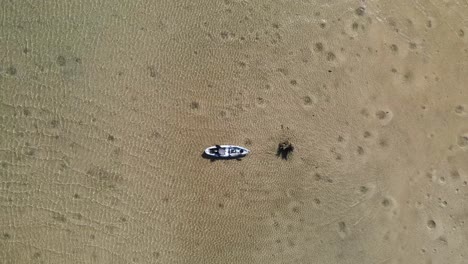 un kayak atado al tocón de un árbol flota tranquilamente en las aguas cristalinas de una isla de arena natural