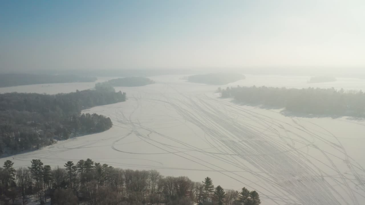 겨울철 눈으로 덮인 얼어붙은 호수 위의 공중 설상차 차량 트랙