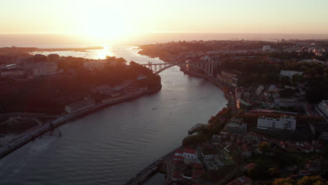 vista del río con puente y la ciudad durante la puesta de sol en el horizonte, porto, portugal