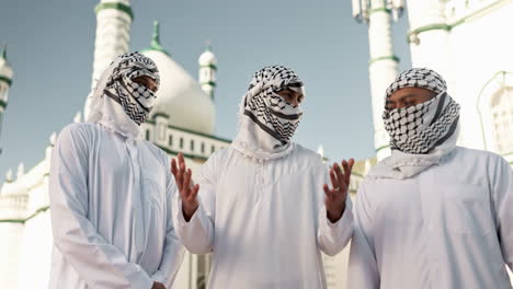 group of men in traditional arab clothing in front of a mosque