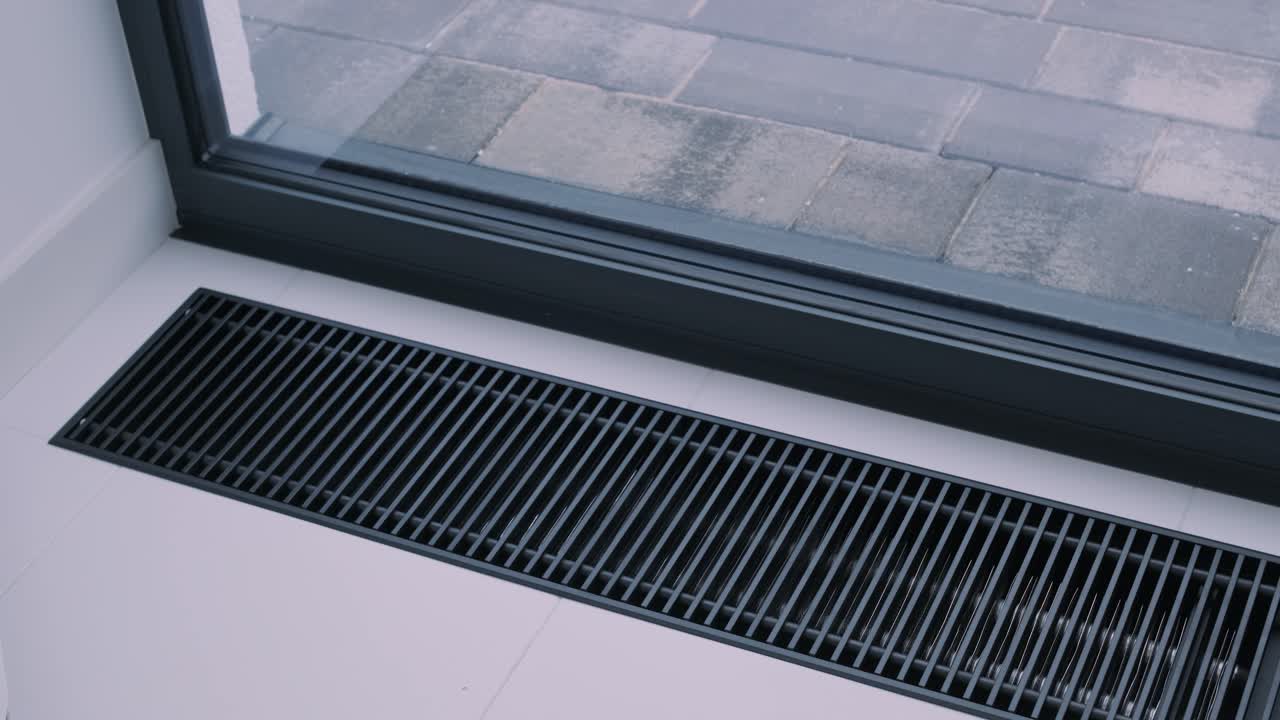 Protective radiator grille built into the floor for heating panoramic windows. Heating grid with ventilation by the floor in hardwood flooring